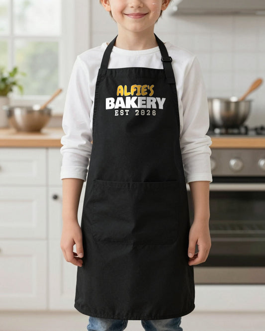 Kids Name's Bakery Est Year kids apron in Black, worn, our photo