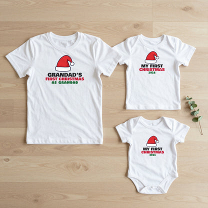 Grandad's First Christmas & My First Christmas matching set flat lay on oak floor: grown-up tee, kids tee and baby grow