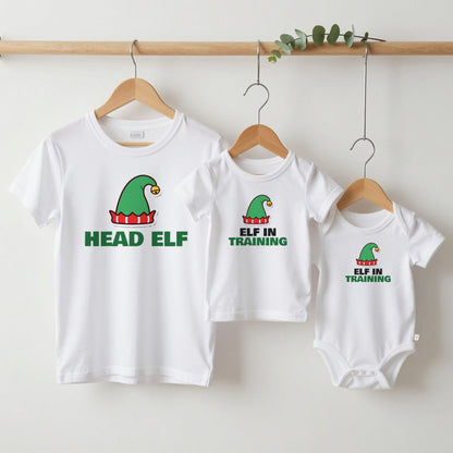 Head Elf & Elf in Training Christmas matching set grown-up tee, kids tee and baby grow on hangers
