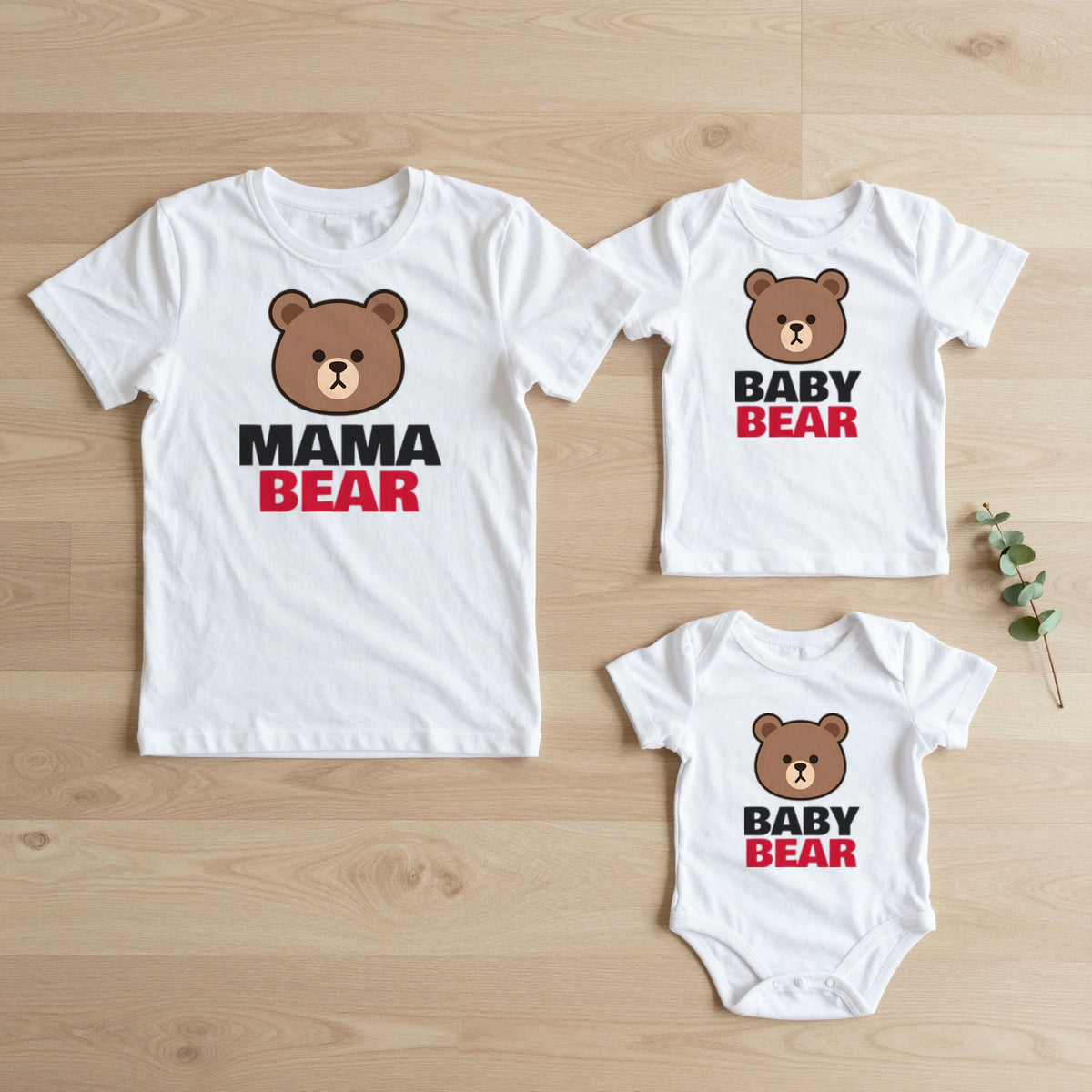 Mama Bear & Baby Bear Mum and Baby Set matching set flat lay on oak floor: grown-up tee, kids tee and baby grow