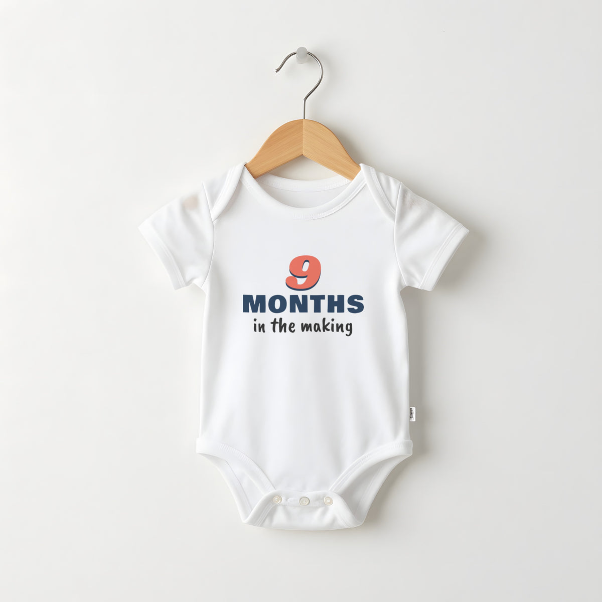 9 Months In The Making white baby grow on a hanger