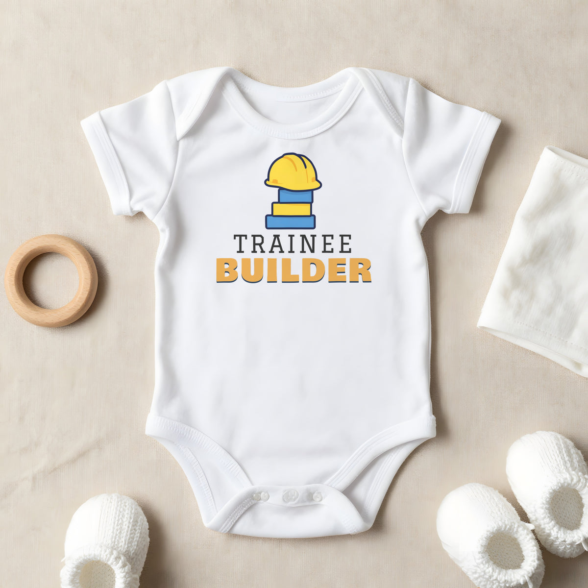 Trainee Builder baby grow laid flat
